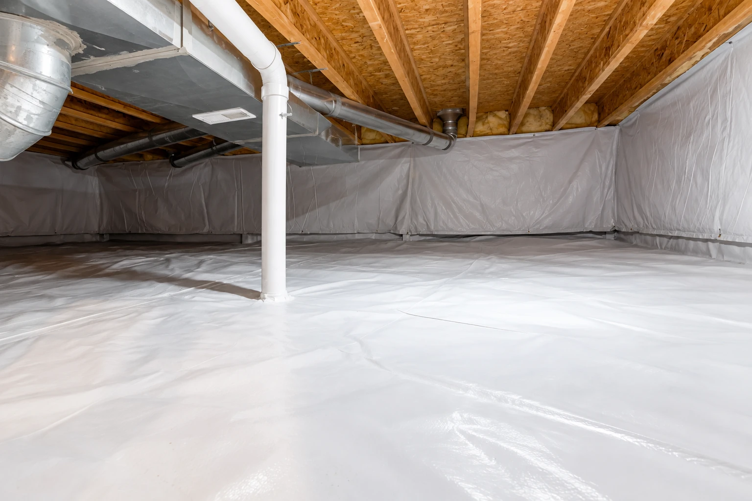 A crawl space has white vapor barrier sheeting across the floor and walls beneath exposed joists and ductwork.