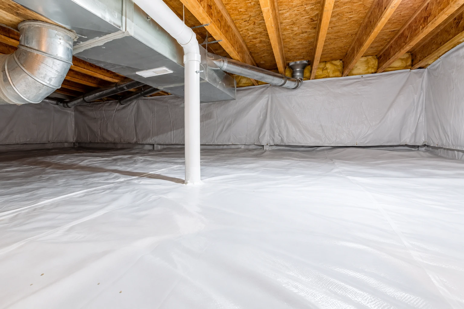 White vapor barrier covers a crawl-space floor and walls beneath exposed joists, ducts, and a central support pipe.